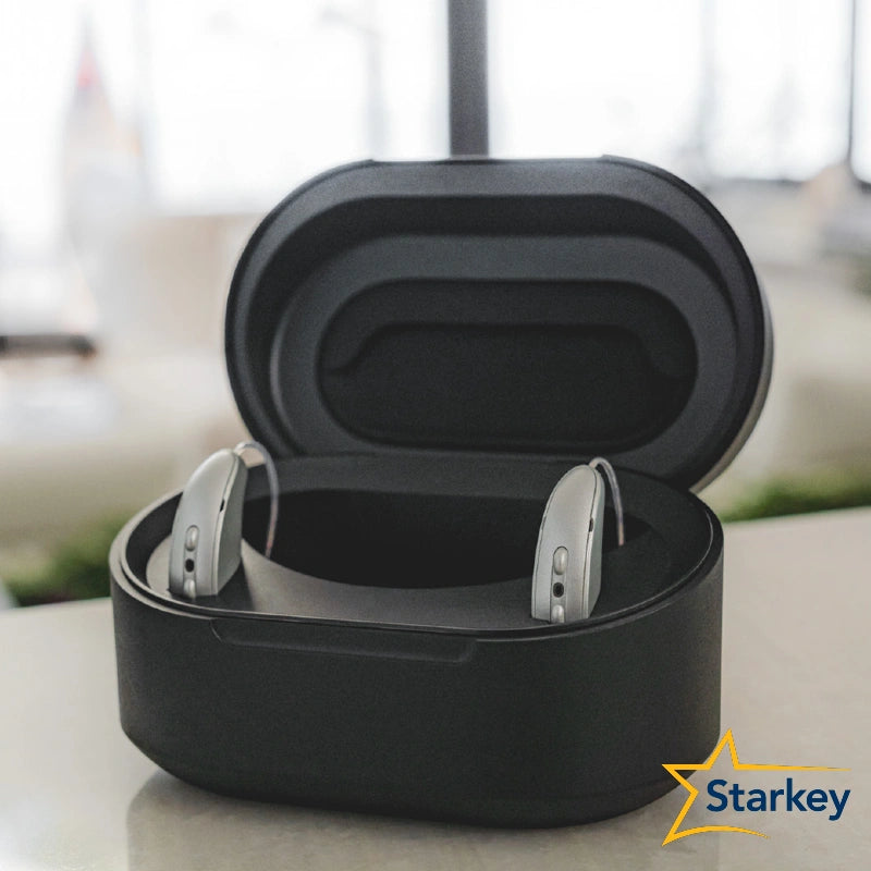 Chargeur Starkey ouvert avec deux aides auditives grises dans leur boîtier.