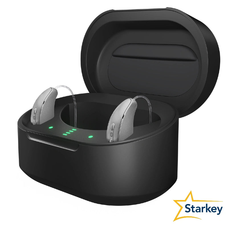 Chargeur Starkey ouvert contenant deux aides auditives grises, avec indicateurs lumineux verts.